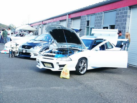 2001 Mercury Grand Marquis - Modified white coupe and blue car at an event, with trophies on display.