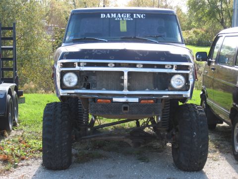 1977 Ford F-150 - Front view of a lifted black 1977 Ford F-150 with a custom grille and "DAMAGE INC 4x4 Club" sticker on the windshield.