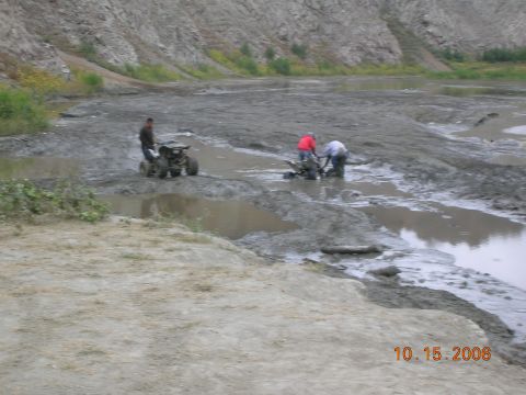 1985 Ford Bronco - People and ATVs navigate a muddy, off-road quarry environment.