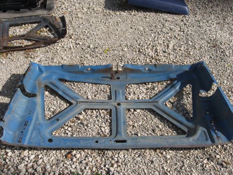 1977 Ford F-150 - A blue metal car part, possibly a hood reinforcement, is shown from the underside on a gravel surface.