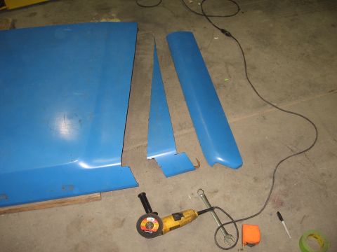 1977 Ford F-150 - Disassembled blue car body panels and tools are laid out on a workshop floor.