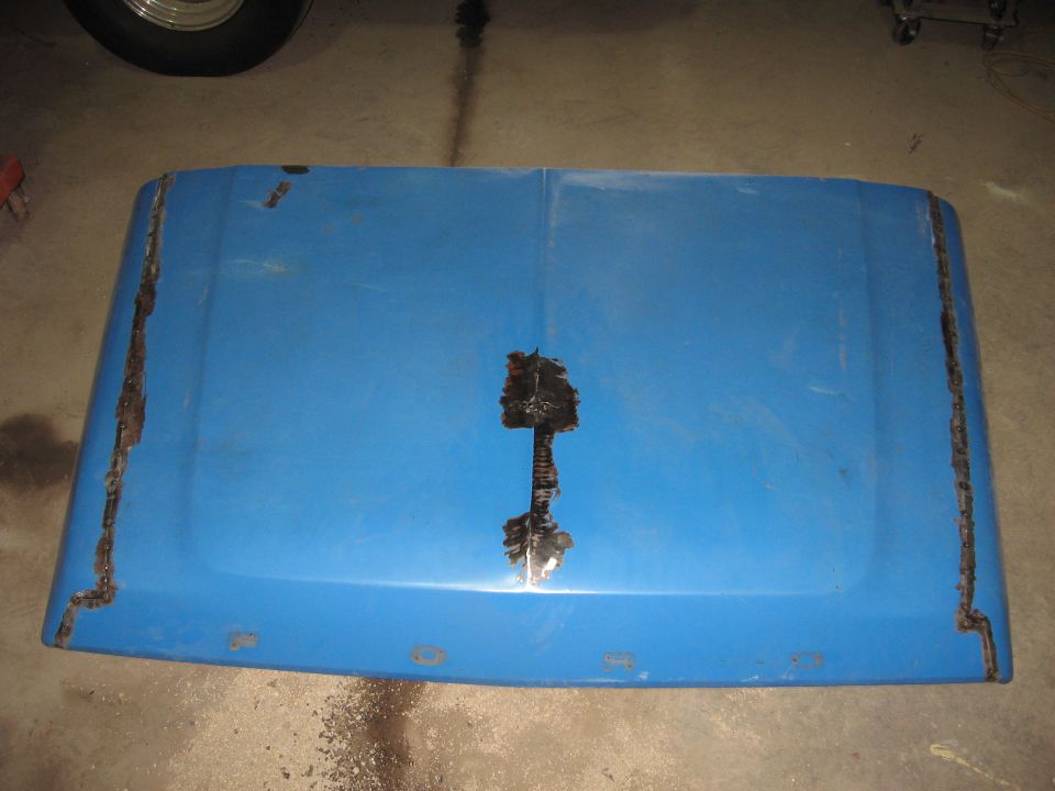 Blue truck hood with significant rust along edges and center