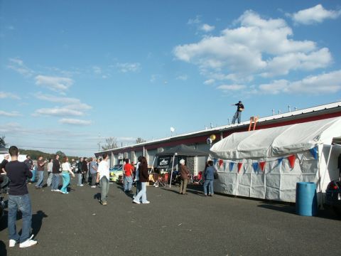 2001 Mercury Grand Marquis - A crowd gathers at an outdoor event, with a yellow car visible among the attendees and temporary structures.