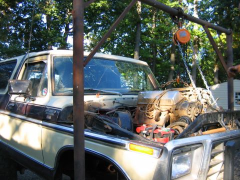 1992 Ford Mustang - A beige and brown 1978 Ford Bronco's engine is being removed with a hoist.