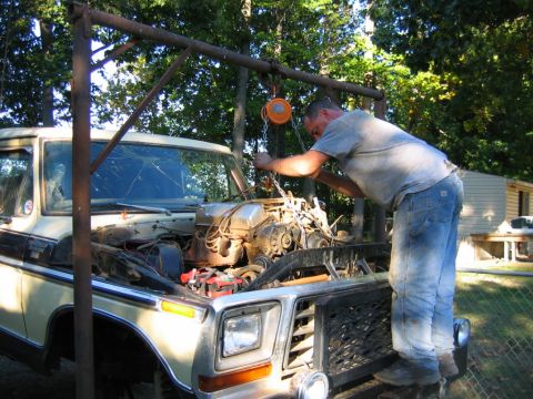 1992 Ford Mustang - A man uses an engine hoist to remove the engine from a vintage Ford F-Series truck.