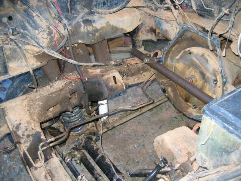 1992 Ford Mustang - Close-up view of a heavily soiled engine bay, showing suspension parts and wiring harnesses.