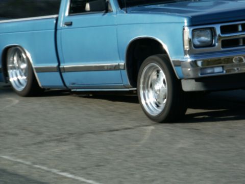 2001 Mercury Grand Marquis - A blue pickup truck with custom chrome wheels and lowered suspension is shown from the side.