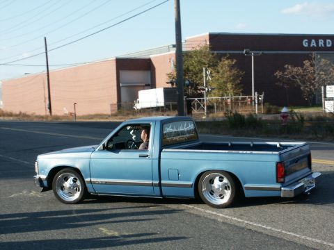 2001 Mercury Grand Marquis - Lowered light blue pickup truck with custom wheels seen from the side.