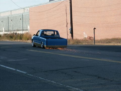 2001 Mercury Grand Marquis - Blue pickup truck with gold trim is seen driving on a road, emitting sparks from the rear.