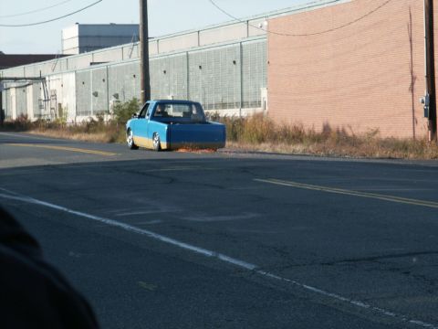 2001 Mercury Grand Marquis - A custom pickup truck with a two-tone paint job is seen driving down the road, with sparks emanating from its rear.
