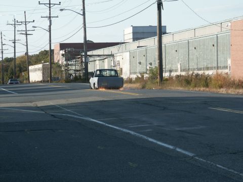 2001 Mercury Grand Marquis - A gray pickup truck is seen from behind with sparks emanating from its rear wheels as it drives down a road.