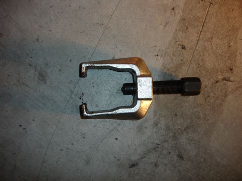 1996 Ford Bronco - A ball joint separator tool rests on a concrete surface, ready for use.
