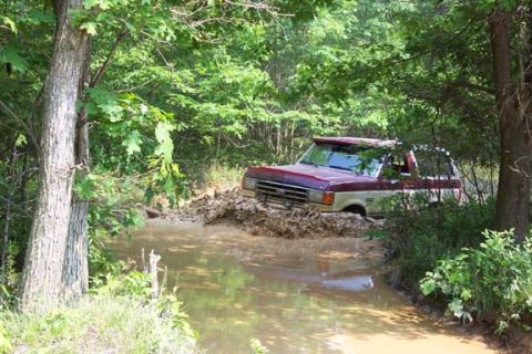 2001 Ford Escape - This vehicle is navigating a challenging off-road trail, getting stuck in the mud.