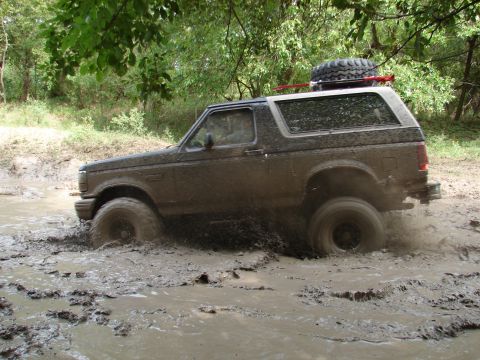 1996 Ford Bronco - This 1996 Ford Bronco navigates a muddy trail, with its spare tire mounted on the roof rack.