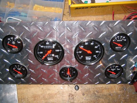 1979 Ford Bronco - A custom gauge panel with multiple readouts is mounted on a diamond plate surface, with wiring and electrical connectors visible.