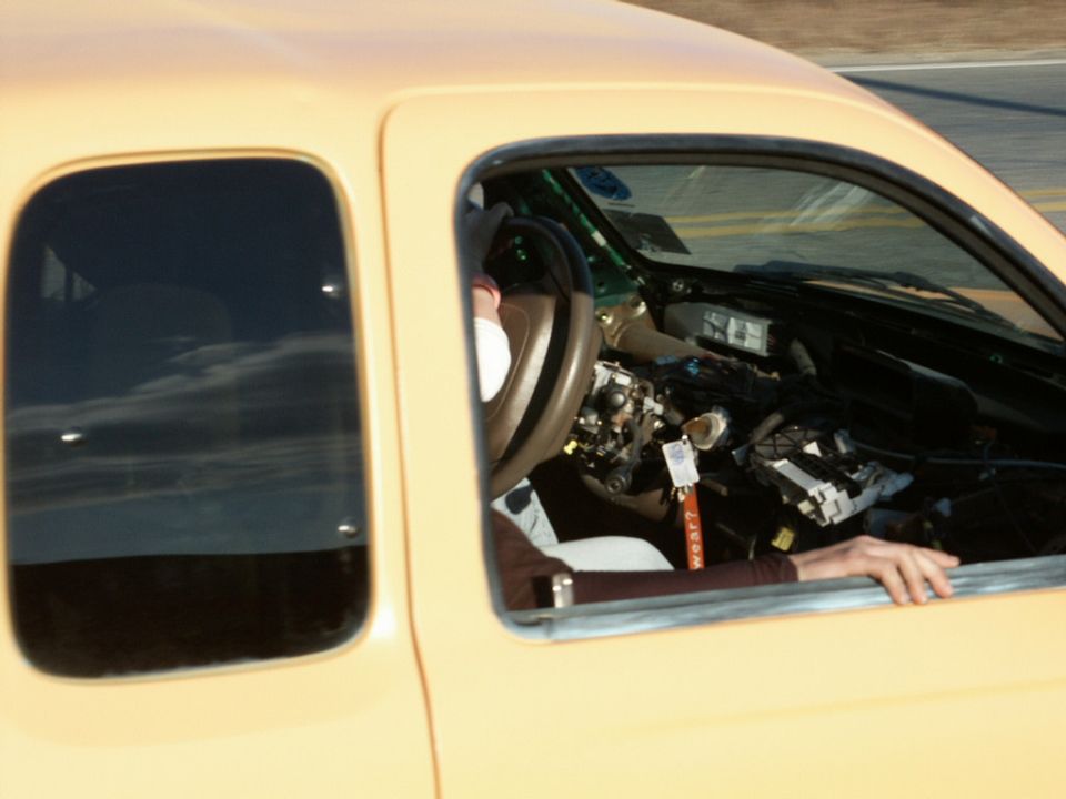 Interior of a yellow car with dashboard removed and wiring exposed