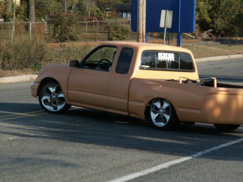 2001 Mercury Grand Marquis - Customized pickup truck with aftermarket wheels and a dropped suspension sits on the asphalt.