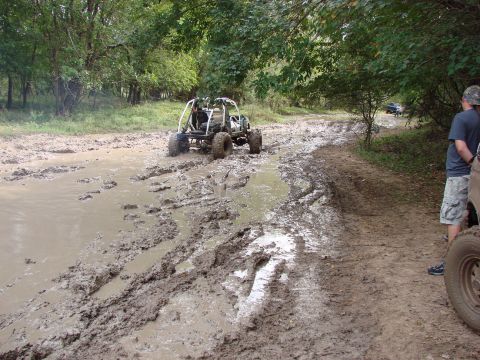 1996 Ford Bronco - An off-road buggy struggles through a muddy trail with another vehicle visible in the distance.