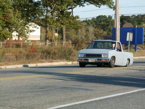 2001 Mercury Grand Marquis - A Nissan Hardbody pickup truck is seen driving on a road with a lowered suspension.