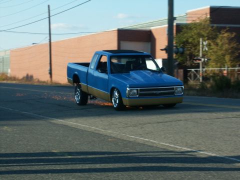 2001 Mercury Grand Marquis - A modified pickup truck is seen in motion on a street, with sparks emanating from its rear wheel.