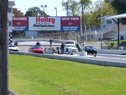 1991 Ford Probe - Cars are staged at the starting line of a drag strip under a large Holley Performance banner.