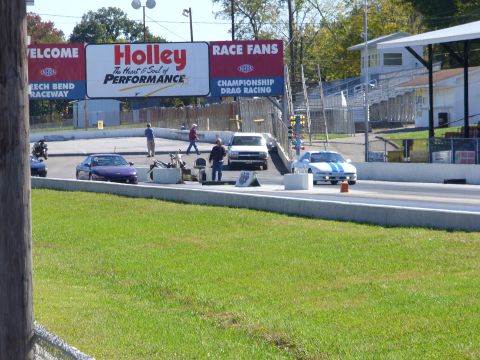 1991 Ford Probe - Cars prepare for a drag race at Beech Bend Raceway under a large Holley Performance banner.