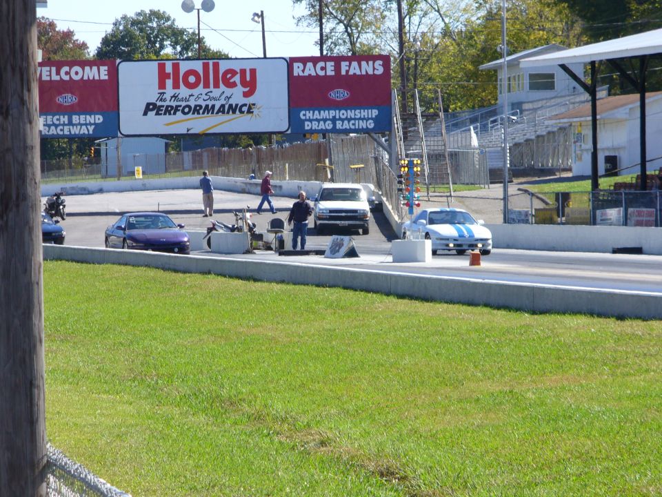 Drag strip with cars lined up, Holley banner overhead