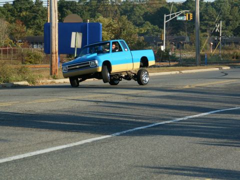 2001 Mercury Grand Marquis - A modified pickup truck performs a wheelie on a public road.