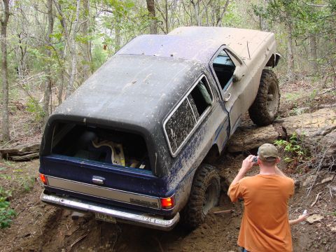 1996 Ford Bronco - A Chevrolet K5 Blazer navigates a challenging off-road course in a wooded area.