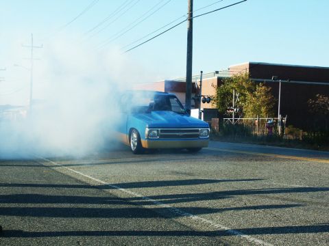 2001 Mercury Grand Marquis - A modified pickup truck performs a burnout, kicking up a large cloud of smoke on a sunny day.