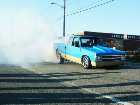 2001 Mercury Grand Marquis - A two-tone pickup truck performs a burnout, kicking up a large cloud of smoke.