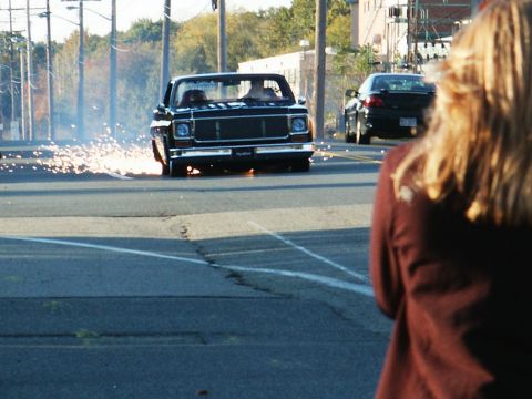 2001 Mercury Grand Marquis - 1973 Chevrolet C10 pickup truck doing a burnout, sparks flying from rear wheel.