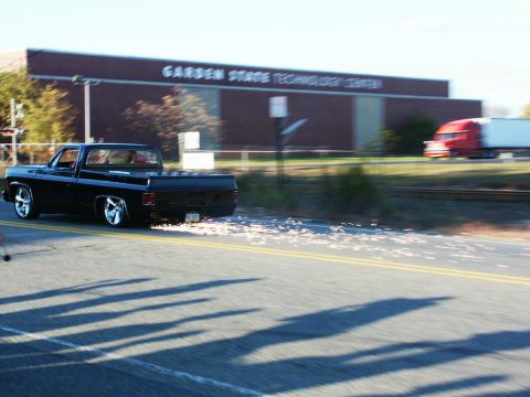2001 Mercury Grand Marquis - A black pickup truck with custom chrome wheels kicks up sparks as it drives past the Garden State Technology Center.