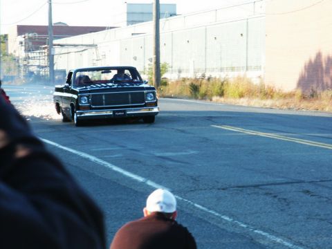 2001 Mercury Grand Marquis - A black pickup truck drives down a road, kicking up sparks from its wheels.