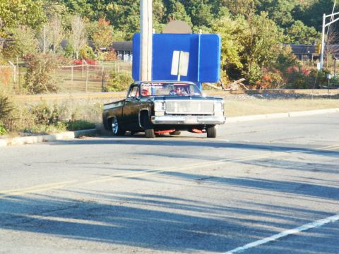 2001 Mercury Grand Marquis - A black pickup truck with custom red undercarriage lighting is parked near a street sign.
