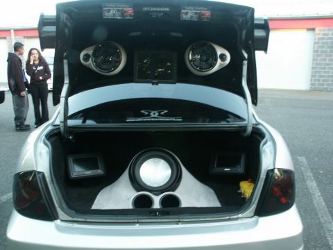 2001 Mercury Grand Marquis - The trunk of a car is open, revealing a custom audio setup with multiple speakers and screens.