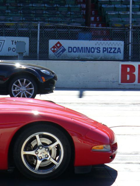 1991 Ford Probe - Two sports cars are visible on a track with advertising in the background.