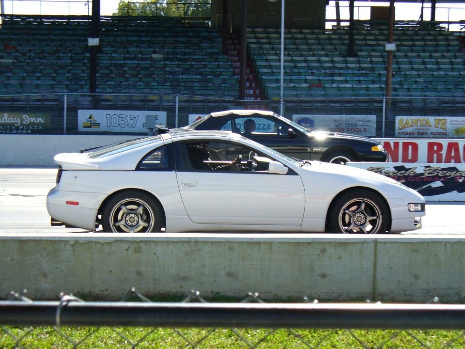 White Nissan 300ZX parked next to a black convertible at a racetrack