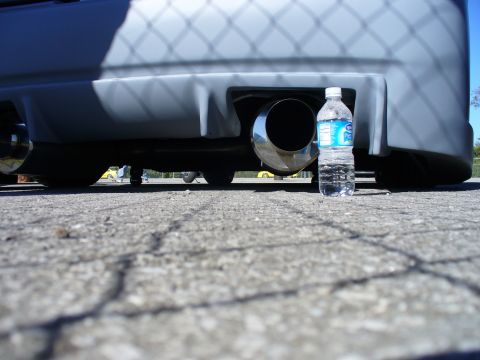 1991 Ford Probe - Close-up of a car's exhaust pipe and rear bumper, with a water bottle for scale.