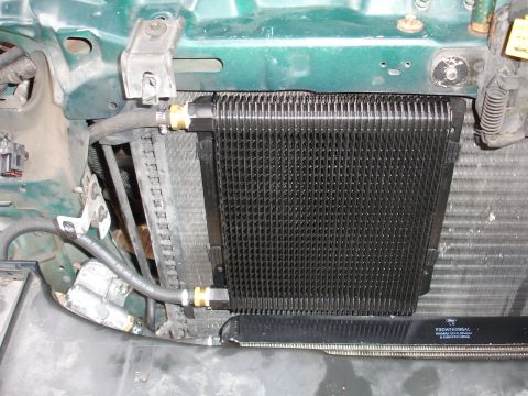 1993 Ford Taurus - Aftermarket transmission cooler installed in a vehicle's engine bay.