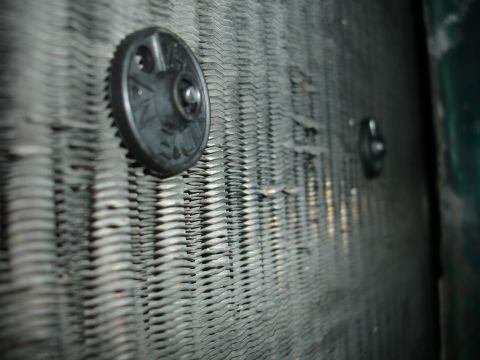1993 Ford Taurus - The image shows a close-up view of a radiator's fins and two black fasteners attached to it.