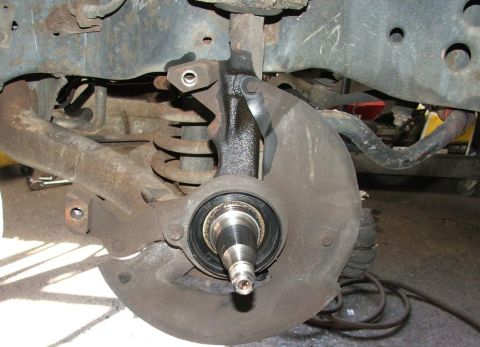 1985 Ford Crown Victoria LTD - This image shows the front wheel hub and suspension components of a vehicle, likely during a repair or maintenance procedure.