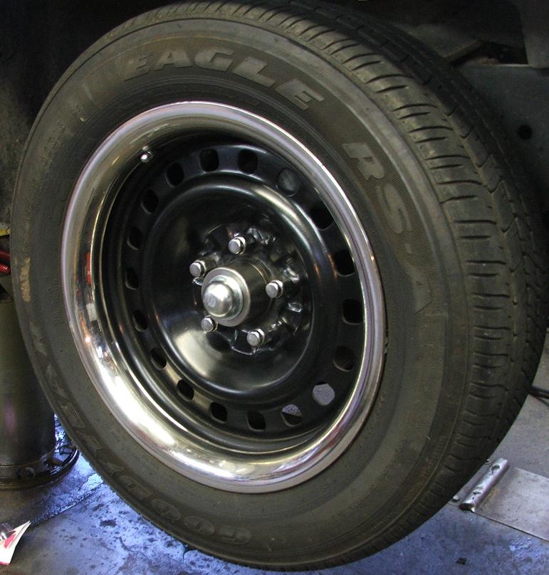 Black steel wheel with chrome lip on Goodyear Eagle RS-A tire, hubcap off exposing 5-lug hub