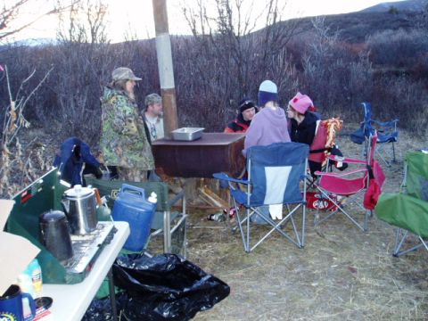 2000 Ford E350 - People are gathered around a table in an outdoor setting, with camping equipment visible.