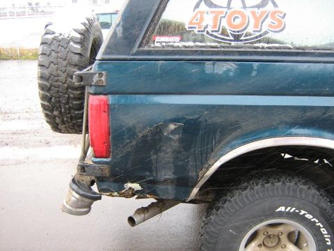 1995 Ford Bronco - Rear view of a 1995 Ford Bronco, a spare tire mount and visible rust.