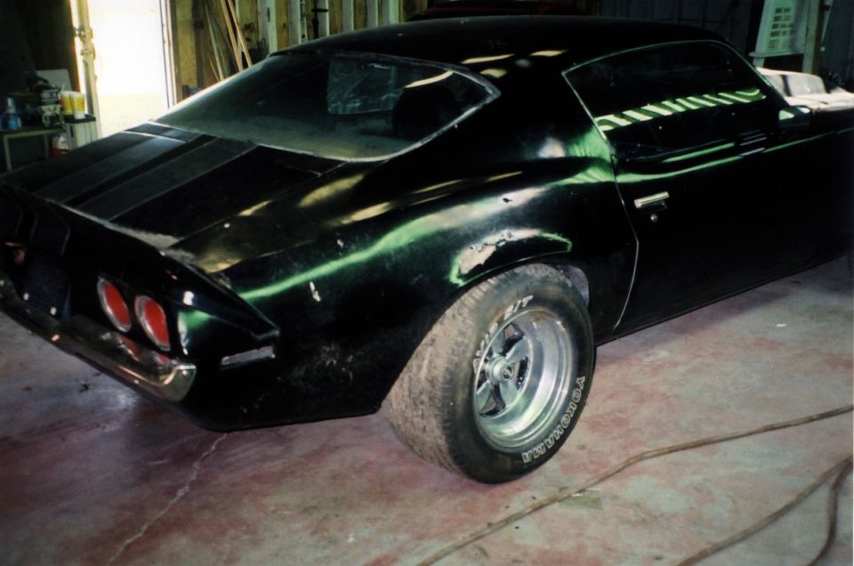 Black 1971 Chevrolet Camaro coupe rear three-quarter view in a garage with Yokohama tires on alloy wheels