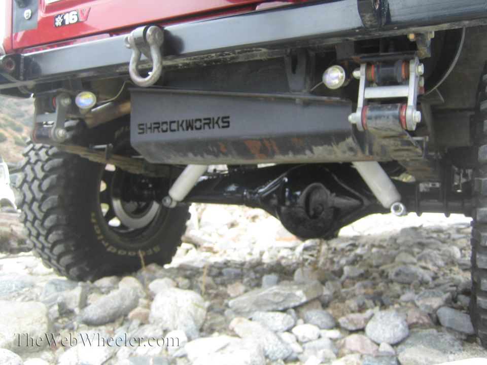 Red off-road vehicle rear axle with Shrockworks skid plate and BFGoodrich tires