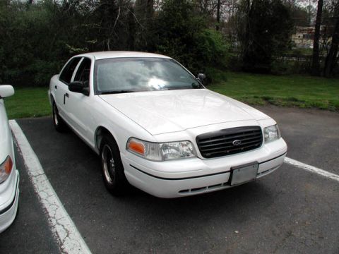 1998 Ford Crown Victoria - A white 1998 Ford Crown Victoria is parked in a lot, viewed from the front three-quarter angle.