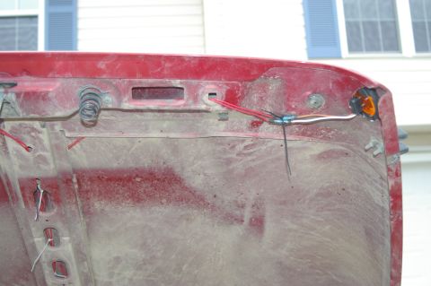 1998 Jeep TJ - Close-up view of the interior of a red Jeep hood, revealing wiring and springs.