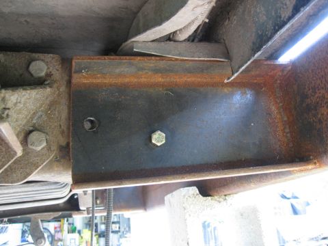 1974 Ford F-100 - Close-up of a rusted metal frame section with visible bolts and straps, showing Supermotors branding.